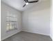 Neutral bedroom showing light wood floor, ceiling fan, window with blinds and simple finishes at 2444 Omaha Dr, Deltona, FL 32738