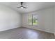 Bedroom with a modern ceiling fan, neutral decor, and a large window at 2444 Omaha Dr, Deltona, FL 32738