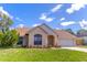 Charming single-story home with a brick facade, well-maintained lawn, and attached garage at 2444 Omaha Dr, Deltona, FL 32738