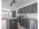 Modern kitchen with stainless steel appliances, gray cabinets, center island, and stylish track lighting at 2444 Omaha Dr, Deltona, FL 32738