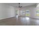 Spacious living room featuring modern ceiling fan, neutral paint, ample natural light, and wood-look floors at 2444 Omaha Dr, Deltona, FL 32738