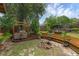Backyard featuring wooden benches and custom fire pit with ample room for outdoor entertainment at 25438 Pine Valley Dr, Sorrento, FL 32776