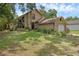 Charming tan home featuring a stone facade, large windows, mature landscaping, and an attached garage at 25438 Pine Valley Dr, Sorrento, FL 32776