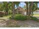 Charming tan home featuring a stone facade, large windows, mature landscaping, and an attached garage at 25438 Pine Valley Dr, Sorrento, FL 32776