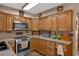 Traditional kitchen featuring wood cabinets, granite countertops, stainless appliances, and ample counter space at 25438 Pine Valley Dr, Sorrento, FL 32776