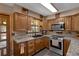 Well-lit kitchen with stainless steel appliances, granite countertops, wood cabinets, and a stainless sink at 25438 Pine Valley Dr, Sorrento, FL 32776