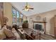 Inviting living room featuring a stone fireplace, large windows, hardwood floors, and comfortable seating at 25438 Pine Valley Dr, Sorrento, FL 32776