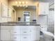 Bathroom with granite countertops, white cabinets, and tiled shower at 2641 Delcrest Dr, Orlando, FL 32817