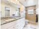 Bright bathroom featuring a granite countertop, white cabinetry, and a tiled shower-tub combo at 2641 Delcrest Dr, Orlando, FL 32817