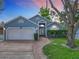 Charming blue single-story home featuring a well-manicured lawn, brick walkway, and attached two-car garage at 2641 Delcrest Dr, Orlando, FL 32817