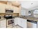 Well-equipped kitchen featuring white cabinets, granite countertops, and stainless steel appliances at 2641 Delcrest Dr, Orlando, FL 32817