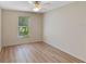 Bright bedroom with wood-look flooring, a ceiling fan, and a window at 26908 Honeymoon Ave, Leesburg, FL 34748