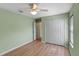 This bedroom features a ceiling fan, light green walls, wood-look floors, and a spacious closet at 26908 Honeymoon Ave, Leesburg, FL 34748