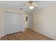 Cozy bedroom features wood-look floors, a closet, and neutral paint at 26908 Honeymoon Ave, Leesburg, FL 34748