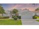 Charming single-story home with a well-manicured lawn and beautiful landscaping, featuring a two-car garage at 26908 Honeymoon Ave, Leesburg, FL 34748