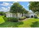Well-maintained house exterior featuring lush green lawn, beautiful trees, and manicured landscaping at 26908 Honeymoon Ave, Leesburg, FL 34748