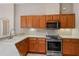 Modern kitchen featuring stainless steel appliances, granite countertops, and ample wood cabinetry at 26908 Honeymoon Ave, Leesburg, FL 34748