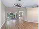 Spacious living room featuring light wood floors, a ceiling fan, and sliding glass doors to the patio at 26908 Honeymoon Ave, Leesburg, FL 34748