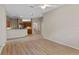 Open-concept living room with wood-look flooring, ceiling fan, and a seamless flow to the kitchen area at 26908 Honeymoon Ave, Leesburg, FL 34748