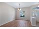 Open living space featuring wood-look floors, large window with natural light, and elegant chandelier at 26908 Honeymoon Ave, Leesburg, FL 34748