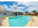 Backyard with a sparkling blue pool, lounge chairs, patio umbrella and a screened lanai with seating at 3024 Saratoga Dr, Orlando, FL 32806