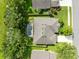 Aerial view of a home featuring a screened-in pool, lush landscaping, and a well-manicured yard at 315 Belhaven Falls Dr, Ocoee, FL 34761