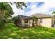 Lush backyard with a screened-in pool area, well-maintained lawn, and mature landscaping at 315 Belhaven Falls Dr, Ocoee, FL 34761