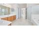 Bright bathroom features a double sink vanity, glass-enclosed shower, tub, and tile floors at 315 Belhaven Falls Dr, Ocoee, FL 34761