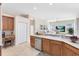Functional kitchen with a sink, dishwasher, wooden cabinets, and a seamless view into the living room at 315 Belhaven Falls Dr, Ocoee, FL 34761