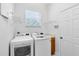 Functional laundry room with modern washer and dryer, white cabinets, and ample shelving at 315 Belhaven Falls Dr, Ocoee, FL 34761