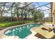 Inviting screened-in pool with spa and lounge chairs, surrounded by a beautifully landscaped backyard at 315 Belhaven Falls Dr, Ocoee, FL 34761
