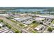 Aerial view showcases commercial buildings and a highway near a community pond and residential area at 3303 Azolla St, Orlando, FL 32808