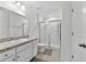 Bright bathroom featuring a shower with sliding glass doors, white cabinets, and neutral countertops at 3303 Azolla St, Orlando, FL 32808