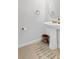 Compact half bathroom featuring pedestal sink, round mirror, and simple, clean design at 3303 Azolla St, Orlando, FL 32808