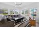 Bright living room features large windows, modern decor, ceiling fan, and comfortable gray sectional at 3303 Azolla St, Orlando, FL 32808
