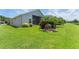 Beautiful backyard with lush green lawn, tropical landscaping and screened in lanai for outdoor entertaining at 3419 Fernwood Dr, Kissimmee, FL 34741