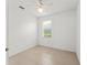 A cozy bedroom with neutral walls and tiled floors, enhanced by natural light at 3419 Fernwood Dr, Kissimmee, FL 34741