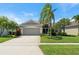 Well-maintained single-Gathering home with a lush lawn, mature trees, and a two-car garage at 3419 Fernwood Dr, Kissimmee, FL 34741