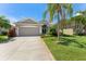 Charming single-Gathering home with well-manicured lawn, lush tropical landscaping, and a two-car garage at 3419 Fernwood Dr, Kissimmee, FL 34741
