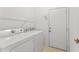 A well-lit laundry room features a washer, dryer, and shelving for convenience at 3419 Fernwood Dr, Kissimmee, FL 34741
