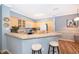 Kitchen featuring light wood cabinets, breakfast bar, stainless steel appliances, and modern lighting fixtures at 3707 Conroy Rd # 1715, Orlando, FL 32839