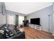Bright living room with hardwood floors, leather couch, and natural light at 3707 Conroy Rd # 1715, Orlando, FL 32839