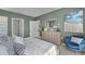 Stylish bedroom with a plush queen bed, blue velvet chair, and a view into an open hallway at 3711 Bluethread Way, Poinciana, FL 34759