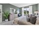 Bright bedroom showcasing a large window view, a plush queen bed, and stylish modern decor at 3711 Bluethread Way, Poinciana, FL 34759