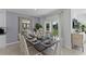 Elegant dining area with a modern table setting and serene backyard views at 3711 Bluethread Way, Poinciana, FL 34759