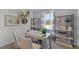 Well-lit home office with modern desk, decorative shelving, striped chairs, and a view at 3711 Bluethread Way, Poinciana, FL 34759