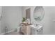 Well-lit powder room features a pedestal sink, decorative mirror, tiled floors, and modern fixtures at 3711 Bluethread Way, Poinciana, FL 34759