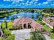 Aerial view showcasing the expansive home with a well manicured lawn, landscaping, and serene lake views at 3728 Hunters Isle Dr, Orlando, FL 32837