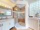 Bathroom featuring marble-top vanity, frameless glass walk-in shower and glass block window at 3728 Hunters Isle Dr, Orlando, FL 32837