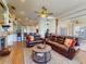 Spacious living room with comfortable leather sofas, ceiling fan, and open layout to the kitchen and dining area at 3728 Hunters Isle Dr, Orlando, FL 32837